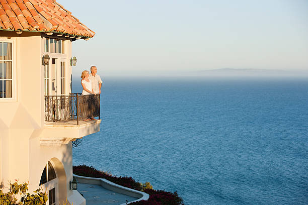 Couple de senior sur le balcon de sa maison en bord de mer